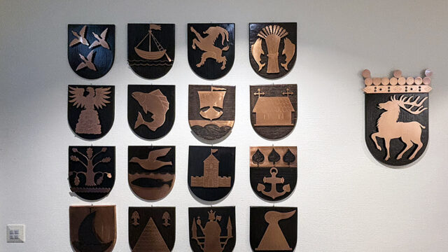 Oasens boende- och vårdcenter drivs av ett kommunalförbund där 13 av Ålands 16 kommuner ingår. På boendet finns samtliga kommunvapen uppsatta, plus Ålands landskapsvapen (längst till höger i bild).